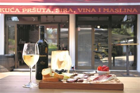 Fotografija elegantnega vinskega bara v Ljubljani z izbrano ponudbo pršuta in sira