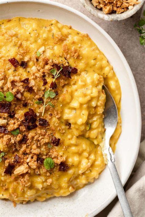 Tematsko foto: skleda črne sipine rižote, posuta s svežim peteršiljem in parmezanom