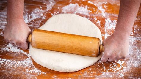 Photo of dough being rolled between baking papers