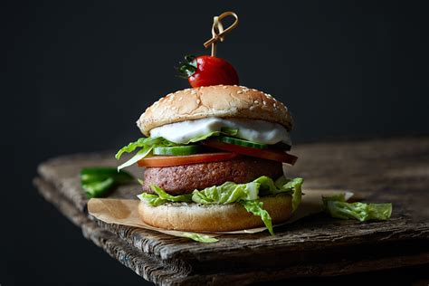 Fotografija sočnega domačega burgerja s popolno stopljenim sirom na vrhu polpete.