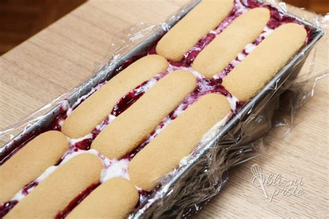 Prikaz plasti jogurtne torte s sadjem in piškoti v prozorni posodi