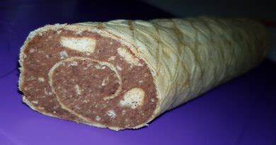 Prirejena čokoladna salama s sadjem in piškoti, narezana na rezine