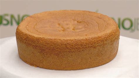 Prikaz ročnega nanašanja zdrobljene kakavove mase na svetli biskvit.