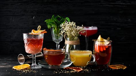 različni elementi za okrasitev poletnih vinskih koktajlov, kot so jagodičevje, rezine citrusov in zelišča