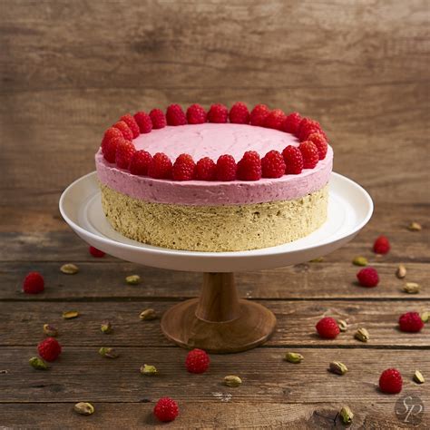 Fotografija elegantne torte iz pistacij in malin z zeleno in rdečo barvo