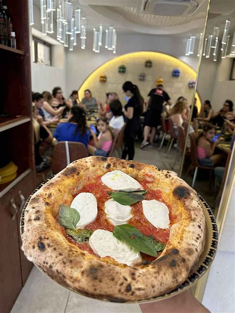 Fotografija zunanje terase Pizzerie Napoli v poletnem vzdušju