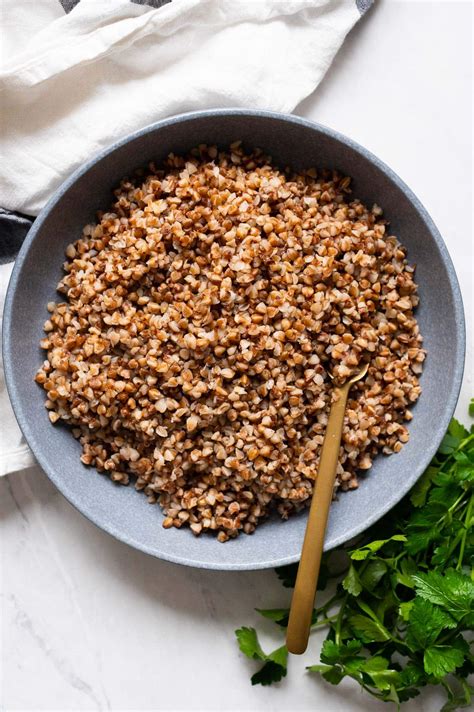 A bowl of freshly cooked buckwheat with herbs and a spoon