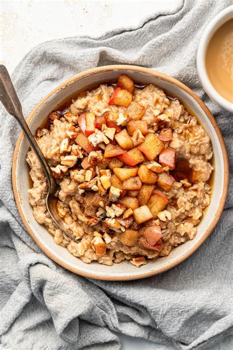 A bowl of buckwheat porridge with sliced apples, nuts, and cinnamon