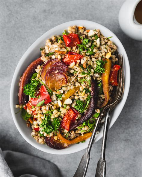 A colorful buckwheat salad with various roasted vegetables and a dressing