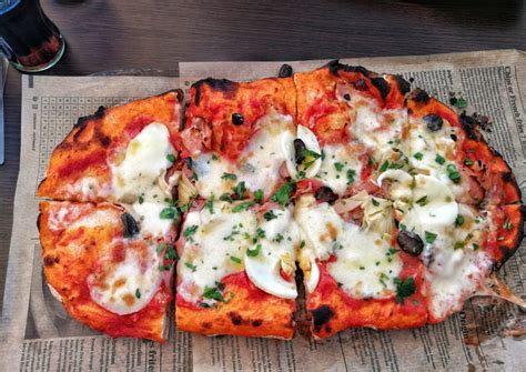 Slika ročno pripravljene pizze z bogatimi nadevi