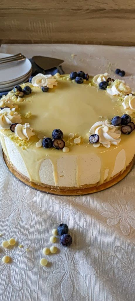 slika torte z borovnicami, belo čokolado in limeto, okrašene s piškotki