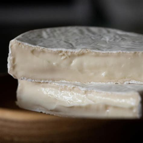 Fotografija sira Camembert, prikazuje belo plesnivo skorjo in morebitno rdečo mašico