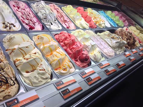 Photo of various scoops of homemade ice cream in a display case.