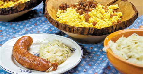 koruzni zganci s kislim zeljem in kranjsko klobaso na krožniku