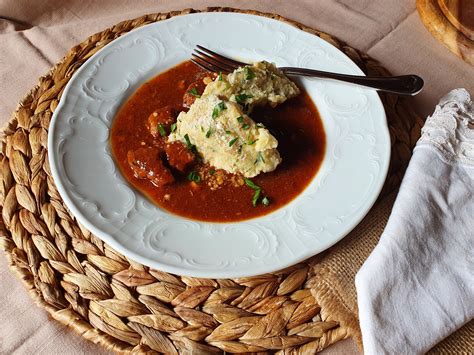 fotografija kuhanih kruhovih cmokov, postreženih z golažem