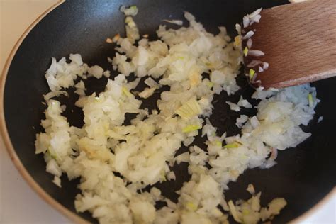 praženje čebule in česna v ponvi za rižoto