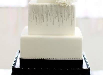 Slikovit prikaz kvadratne poročne torte z minimalistično dekoracijo in ostrimi robovi.