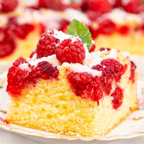 slika preprostega, a sočnega čokoladnega kolača z malinami, narezanega na kocke, posutega s sladkorjem v prahu