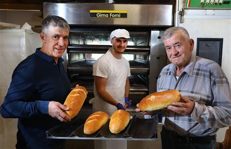 Thematično foto: gospodinja peče kruh v krušni peči, prikaz tradicionalne peke