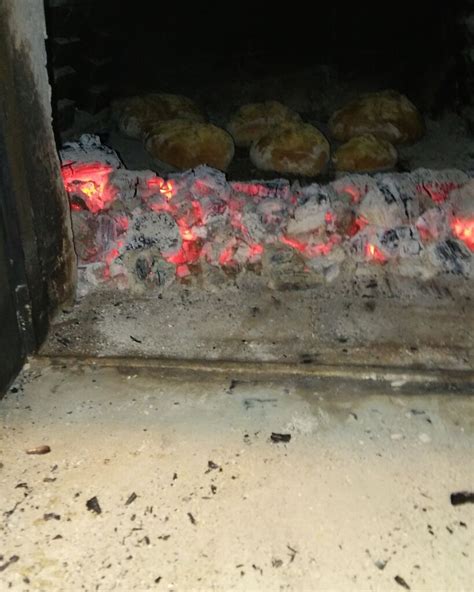 Tematska fotografija pekača kruha v delovanju s sveže pečenim kruhom