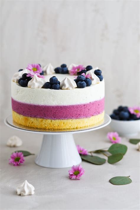 razkošno okrašena borovničeva torta s svežim sadjem in cvetjem