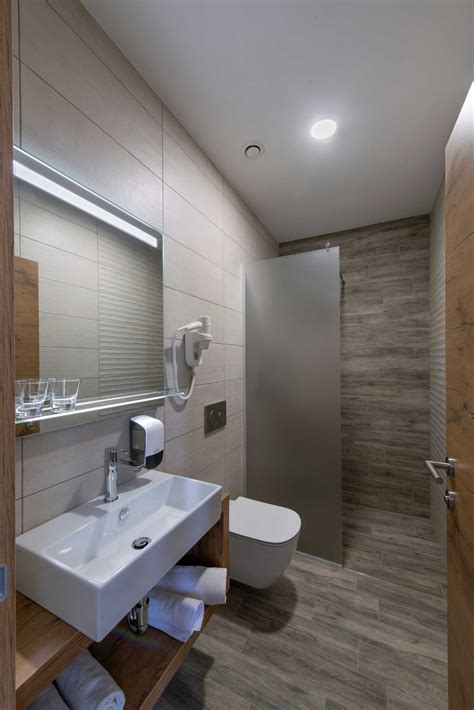 Notranjost elegantno opremljene hotelske sobe z modernim pohištvom in pogledom na naravo.