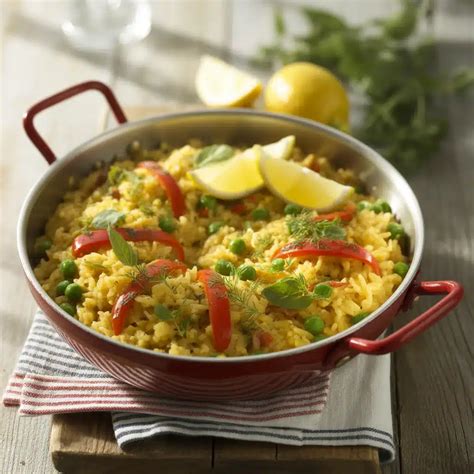 The finished vegan vegetable risotto in a paella pan, garnished with fresh herbs