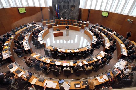Zaslon z napisom Državni zbor med sejo, poudarjajoč razpravo o ključnih vprašanjih