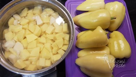 Fotografija postreženih polnjenih paprik s pire krompirjem in kislo smetano.