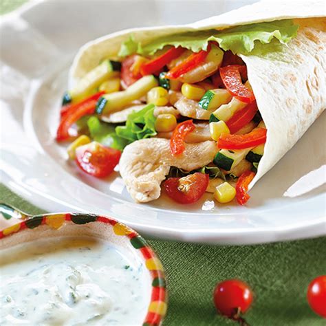 Pikantna omaka v skledici, obdana s svežo zelenjavo in tortilja čipsom.