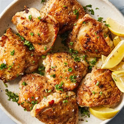 The process of cooking chicken thighs in a pan with a lid for juicy results, showing the steam and browning.