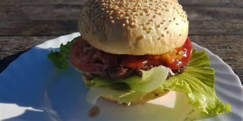 Tematska fotografija domačega hamburgerja z različnimi omakami in sestavinami
