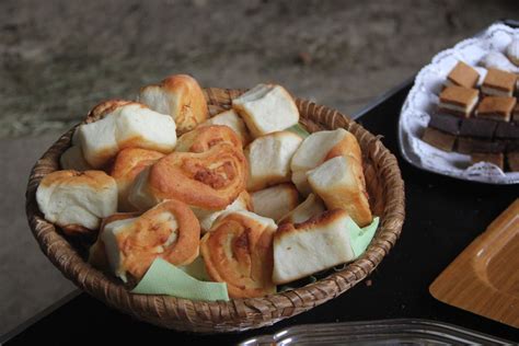 Tematska fotografija: Bogato obložena miza s tradicionalnimi pustnimi jedmi, vključno s svinjskim mesom in krofi.