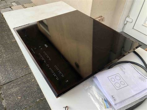 Thematska fotografija sodobne kuhinje z indukcijsko ploščo AEG v uporabi