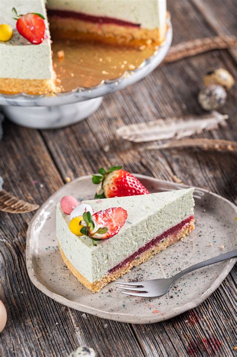 Fotografija nepečenega cheesecakea z belo čokolado, posutega s pistacijami in granatnim jabolkom