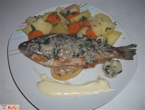 Fotografija servirane pečene ribe z blitvo, krompirjem in rezino limone
