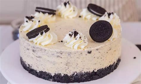 fotografija bogate Oreo torte, okrašene s celimi piškoti in čokoladnim prelivom