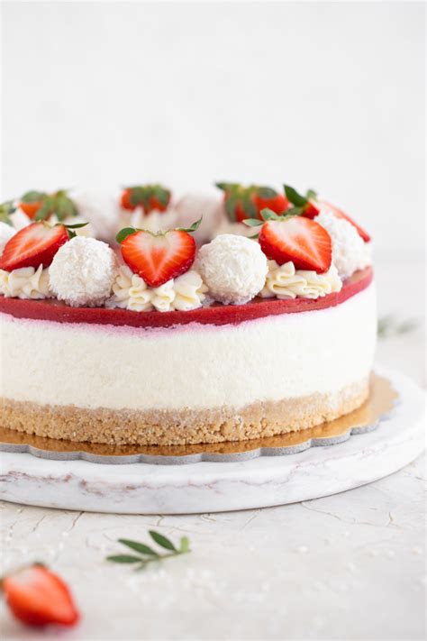 Sestavljena torta s piškotno podlago, jagodami in skutino kremo pred hlajenjem