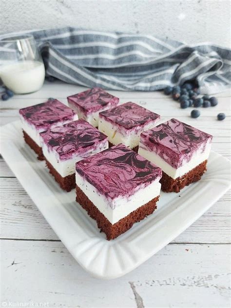 fotografija sveže pečene borovničeve pite, narezane na kocke, z vidno strukturo krhkega testa in sadnega nadeva