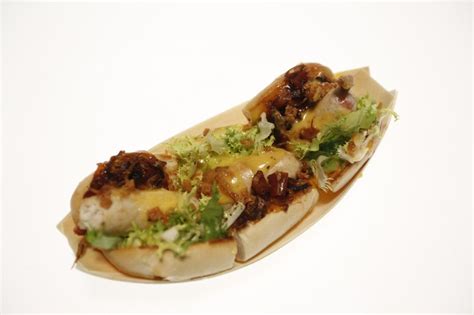 Ilustracija klasičnega hot doga s klobaso, štručko in paradižnikom ter solato.