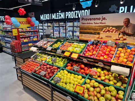 Fotografija svežih slovenskih pomladnih pridelkov, vključno s šparglji in porom, na tržnici ali polici supermarketa