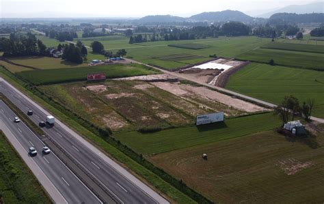 ozka gozdna pot, ki se odpira proti zelenim travnikom planote