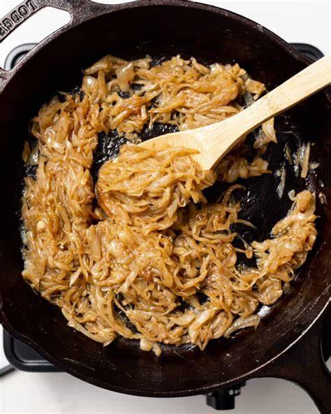Close-up photo of onions being slowly caramelized in a cast iron pot