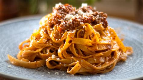 Fotografija krožnika tagliatelle al ragù alla bolognese, s širokimi testeninami in bogato mesno omako