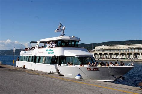Photo of the Delfino Verde boat docking in Grado, with passengers and bikes