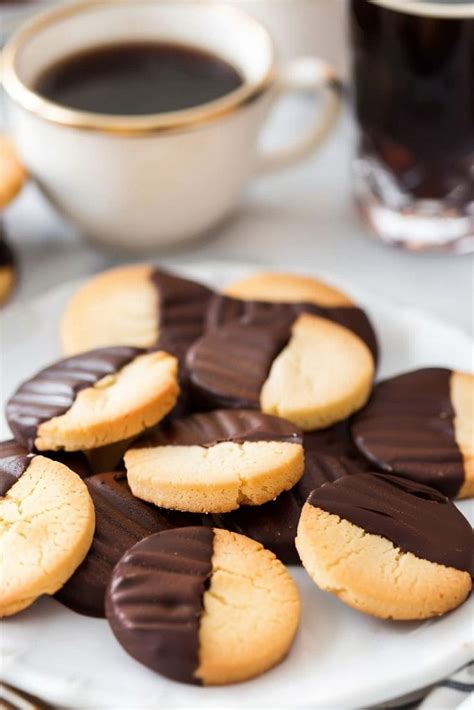 Thematic photo of chocolate sandwich cookies being dipped in milk or coffee