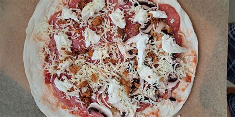 Prikaz ročne razporeditve nadeva na zamrznjeni pici