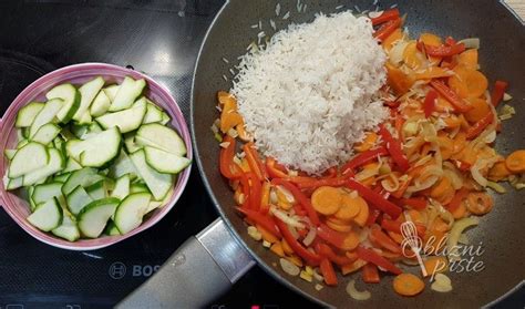 Pripravljen riž s pisano zelenjavo, ki vabi na krožnik.