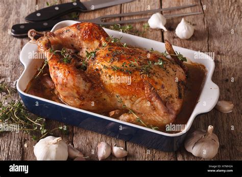 Thematic image: Chicken with 40 cloves of garlic in the dish for baking and ingredients close-up on the table