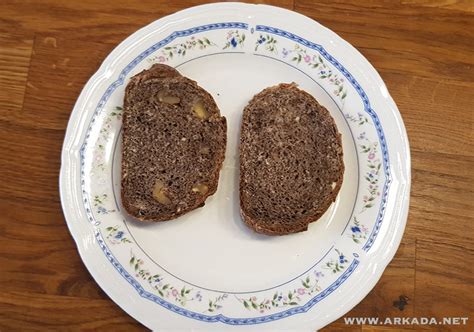 slika mase za presne brownije, enakomerno porazdeljene v pekaču in posute z orehi